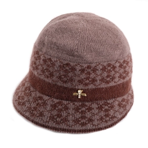 Detailed shot of a brown knit hat featuring soft fur texture and a gold bee rhinestone pin