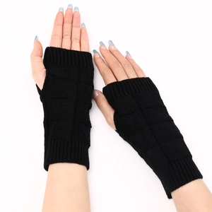 Detail of black knitted fingerless gloves with ribbed cuffs and checkerboard texture