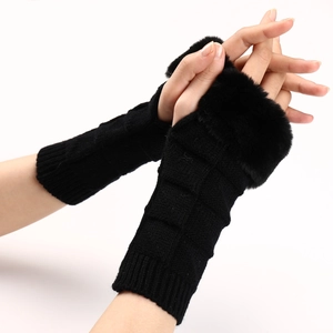 Macro shot of black knitted fingerless gloves with plush faux fur trim and textured patterns