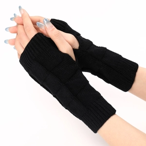 Close-up of black waffle knit fingerless gloves showing ribbing and thumb hole detail