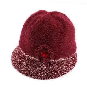 Detail of burgundy knit bucket hat featuring rabbit fur texture and floral decoration