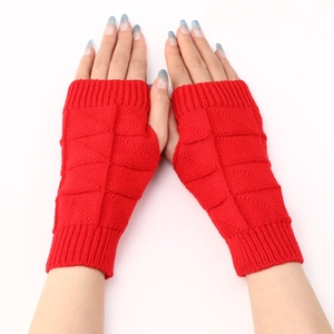 Detail of red knit fingerless gloves showing ribbed cuffs and textured square pattern
