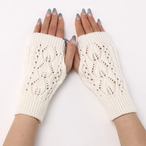 Close-up of cream knitted fingerless gloves with delicate hollow leaf pattern detail