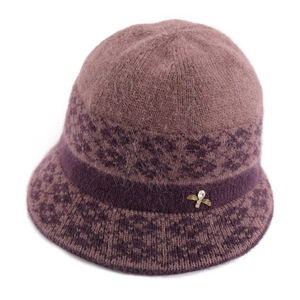 Close-up of pink knit bucket hat with purple jacquard band and gold bee rhinestone pin