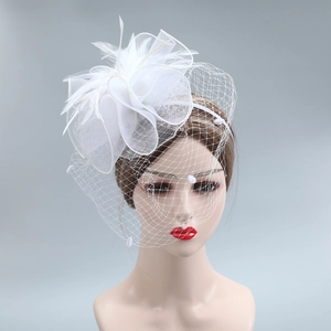 Detail of white fascinator with mesh veil, feathers and floral accents for weddings