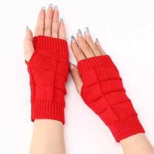 Detailed view of red knitted fingerless gloves with a soft checkered textured pattern