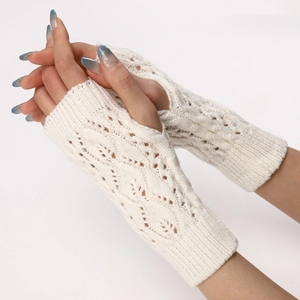 Detailed knit texture of cream white fingerless gloves with elegant hollow out leaf patterns
