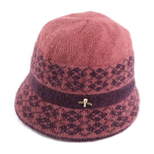 Close-up of pink knit hat with purple floral pattern and luxury metal bee brooch