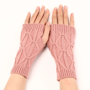 Détail de mitaines en tricot rose poudré avec motif à losanges pour l'hiver au chaud