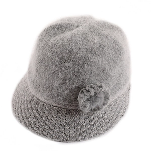 Detail of grey knitted hat featuring fluffy rabbit fur texture and floral decoration