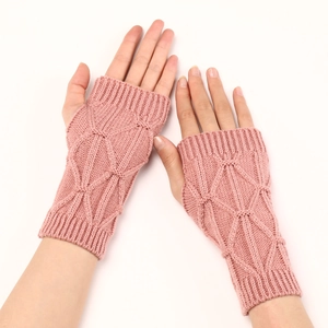 Texture détaillée des mitaines rose clair tricotées avec motifs de losanges