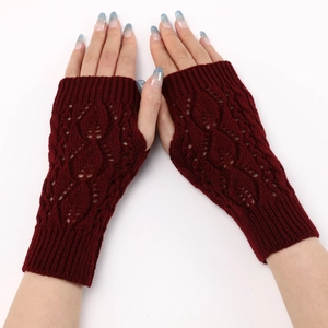 Detail of dark red fingerless knit gloves featuring intricate hollow leaf-like crochet patterns