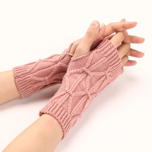 Détail de mitaines en tricot rose avec motif en losange 3D et design sans doigts