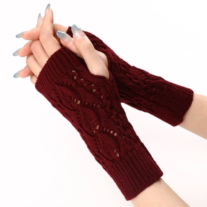 Detail of dark red knit fingerless gloves featuring hollow cable patterns and thumb holes