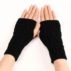Détail macro du tricot à torsades en losange sur des mitaines noires pour l'hiver