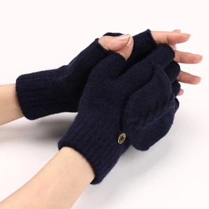 Détail du gant en tricot bleu marine avec motif torsadé et bouton de mode rond