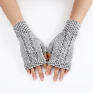 Macro view of light grey cable knit texture on fingerless gloves with twisted patterns