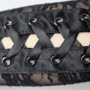 Gros plan détaillé de gants en dentelle noire avec élégants lacets croisés en ruban satin