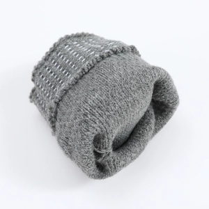 Detail view of dark grey knitted fingerless gloves with white dotted stitch pattern