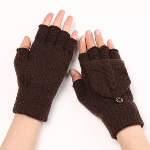Détail de mitaines en tricot torsadé marron avec rabat, bouton et poignet côtelé