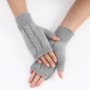 Macro view of grey cable-knit fingerless gloves with ribbed cuffs and soft wool texture