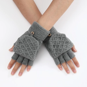 Detail of grey knitted fingerless gloves with a diamond pattern fold-over cover and button