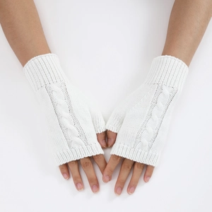 Detail of white cable knit fingerless gloves showing thick texture and weave pattern