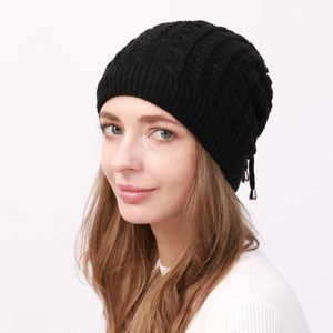 Detail of black cable-knit beanie with soft texture, ribbed cuff and decorative drawstrings