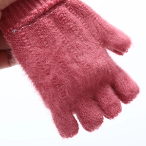 Gros plan sur la texture du gant rose en tricot mohair doux avec poignets côtelés
