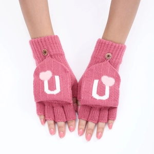 Détail de gants tricotés roses avec cœur blanc et fermeture à bouton pratique