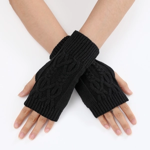 Détail de mitaines en tricot torsadé noir au design sans doigts pour l'automne-hiver