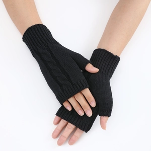 Detail of black cable knit fingerless gloves showing textured pattern and ribbed cuff