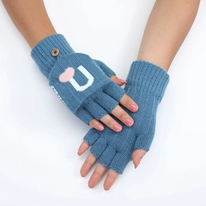 Gros plan de mitaines en tricot bleu avec détail de cœur et bouton en bois