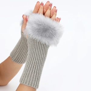Detalle de guantes de punto grises sin dedos con ribete de piel sintética suave de invierno