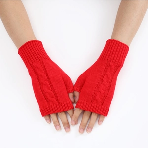 Detail of red cable-knit fingerless gloves showing premium knit texture and pattern