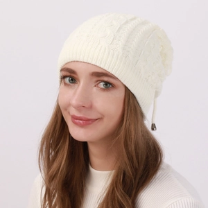 Detailed knit texture and metal pendant on warm off-white beanie for women