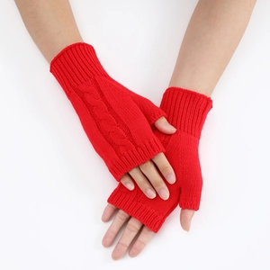 Detail of red cable-knit fingerless gloves showing thumb holes and ribbed cuff