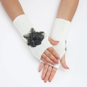 Détails de gants tricotés blancs sans doigts avec élégantes fleurs noires brodées