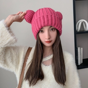 Detailed close-up of thick pink knitted hat with cute bear ears for winter warmth