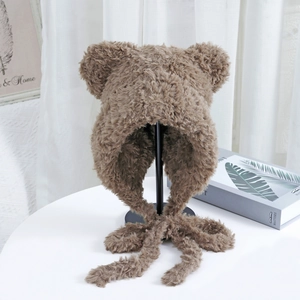 Detailed close-up of soft brown faux fur beanie with cute bear ears and long straps