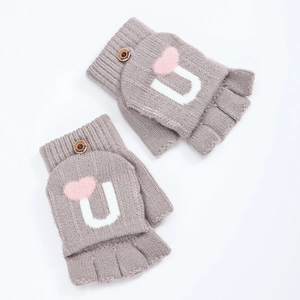 Détail de gants en tricot gris clair avec rabat cœur rose et bouton en bois poli