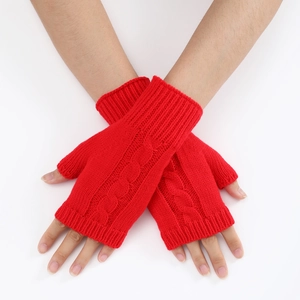 Close-up of red cable knit fingerless gloves showing thick texture and ribbed cuffs