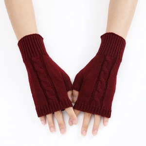 Close-up of wine red cable knit fingerless gloves showing thick winter wool texture