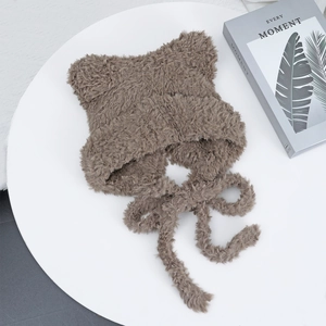 Detail view of brown cat ear plush hat with soft faux fur texture and long tie straps