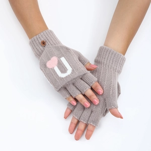 Détail de mitaines en tricot avec motif de cœur et bouton en bois sur le poignet