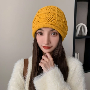 Dettaglio del cappello in maglia giallo brillante con trama a rombi e risvolto ampio morbido