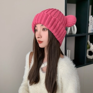 Detailed knit texture of a rose pink beanie with cute 3D bear ears on a model