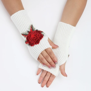 Détail de mitaines en tricot blanc avec broderie de rose rouge sur le dos de la main