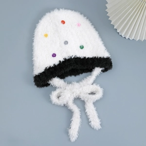 Dettaglio del berretto in peluche con bottoni colorati e bordo in ecopelliccia nera spessa