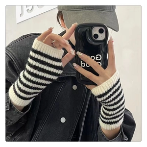 Detail of striped knitted fingerless gloves with white ribbed cuffs for winter warmth